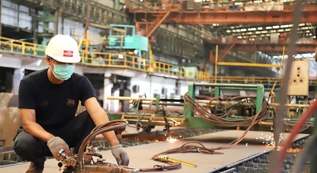 ILUSTRASI. Karyawan PT Gunawan Dianjaya Steel Tbk. memotong pelat baja di pabrik Surabaya. (Frizal/Jawa Pos)