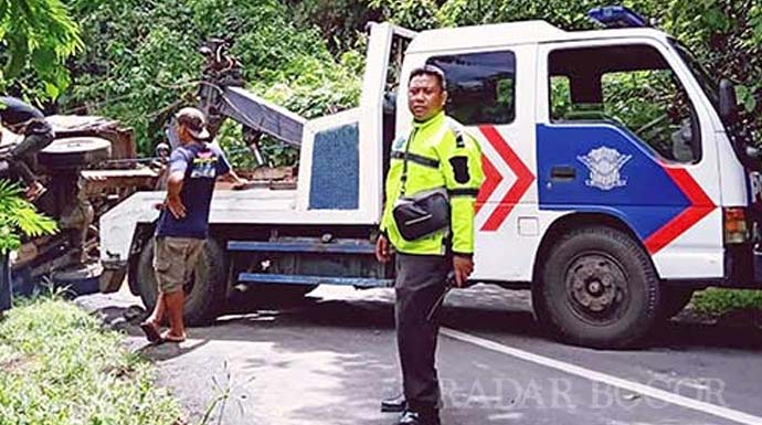 Jajaran Satlantas Polres Sukabumi saat mengevakuasi truk engkel yang terguling di Jalan Cisarakan, Desa Buniwangi, Kecamatan Palabuhanratu, Selasa (7/1).(FT: IST)