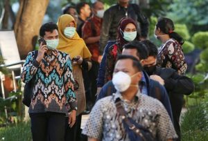 BIKIN HEBOH: Para karyawan yang bekerja di gedung BRI II, Jakarta, mengenakan masker kemarin (23/1). Hal itu memicu isu tentang seorang karyawan Huawei telah terserang virus korona. (MIFTAHULHAYAT/JAWA POS)
